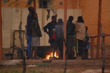The hostel children waiting for the rain to stop so that they can cook their meal of porridge.