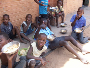 Pupils eating their meal at the only convenient place they can find to sit