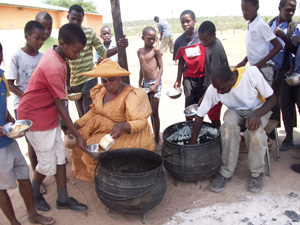Midday meal being served consisting of maize porridge and meat stock